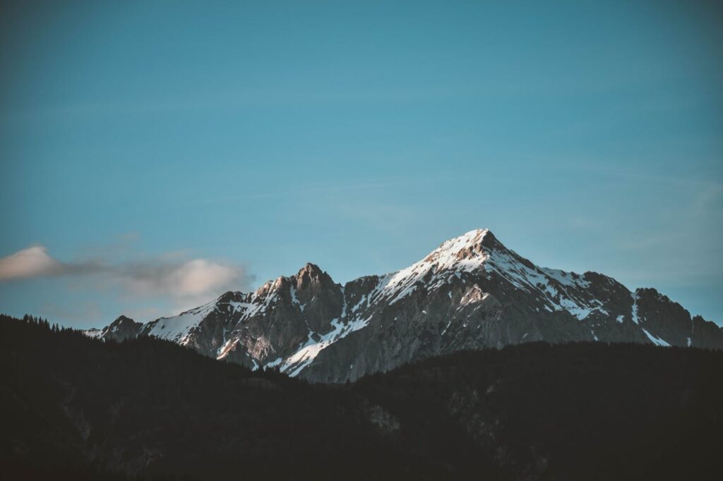 Stunning view of snow-capped mountains against a blue sky, perfect for nature lovers.